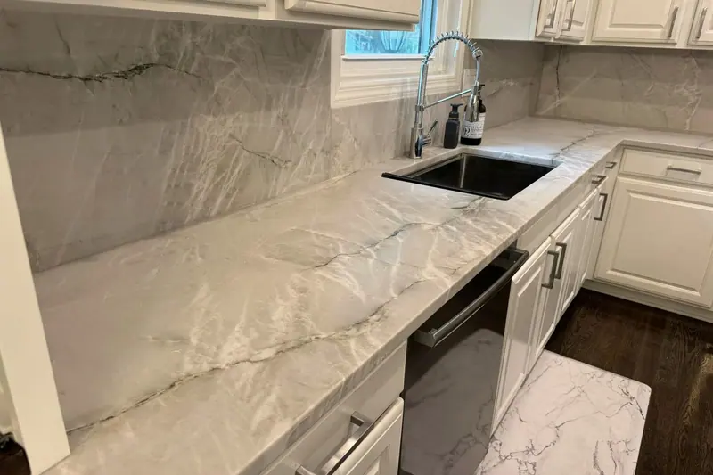 Marble-look quartz counter running up the wall as a slab backsplash