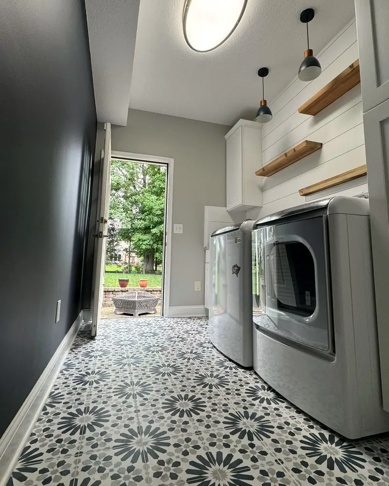 Laundry room with patterned blue and white floor tile, open to the patio